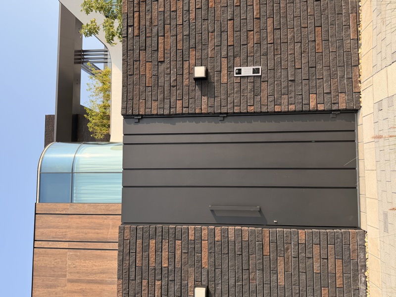 A villa entrance with a video intercom and keypad set into the boundary wall.